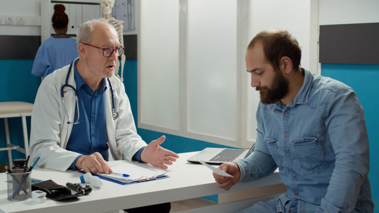 Male Physician giving prescription paper to patient